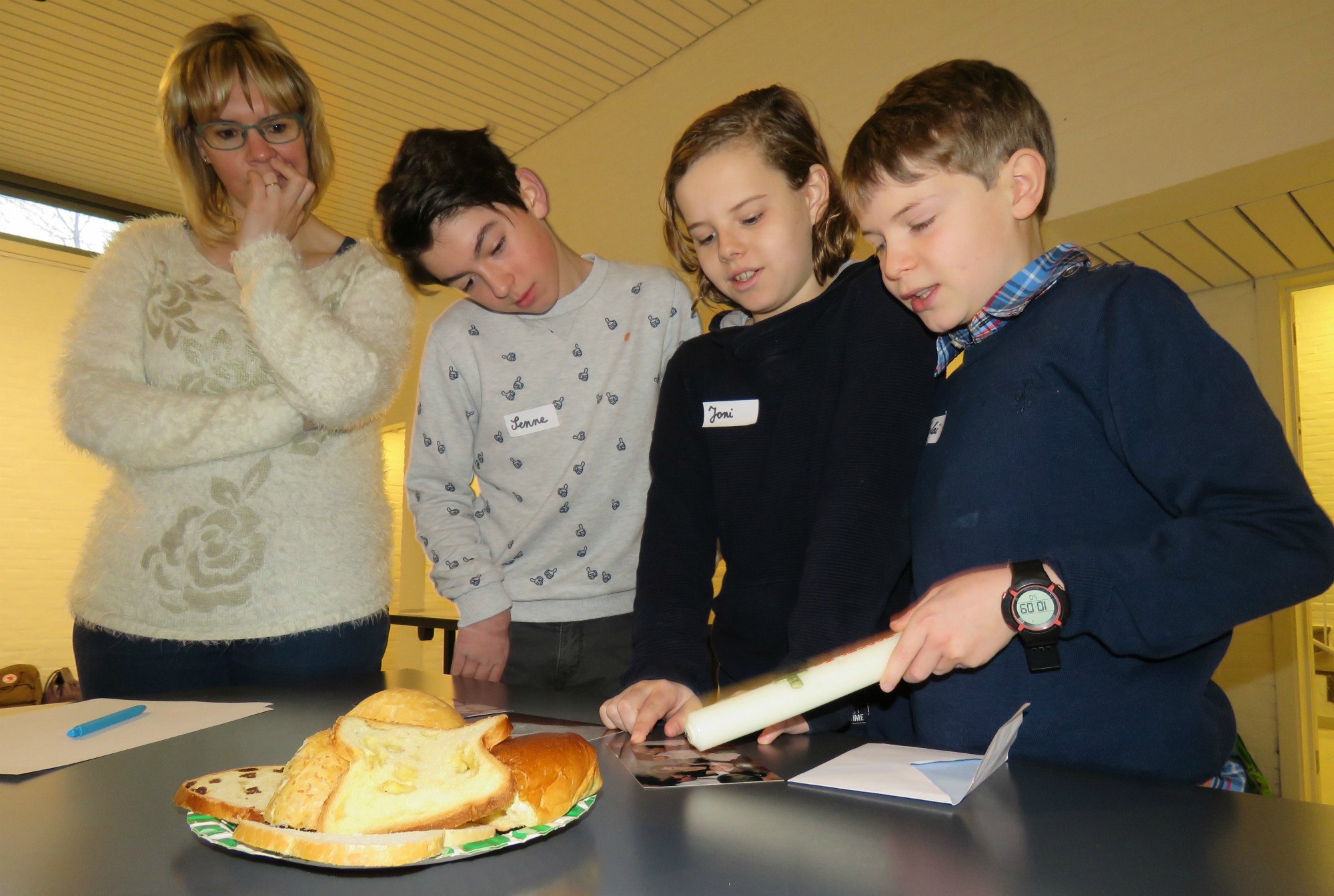 Foto's en kaarsen van de doop worden aan elkaar getoond