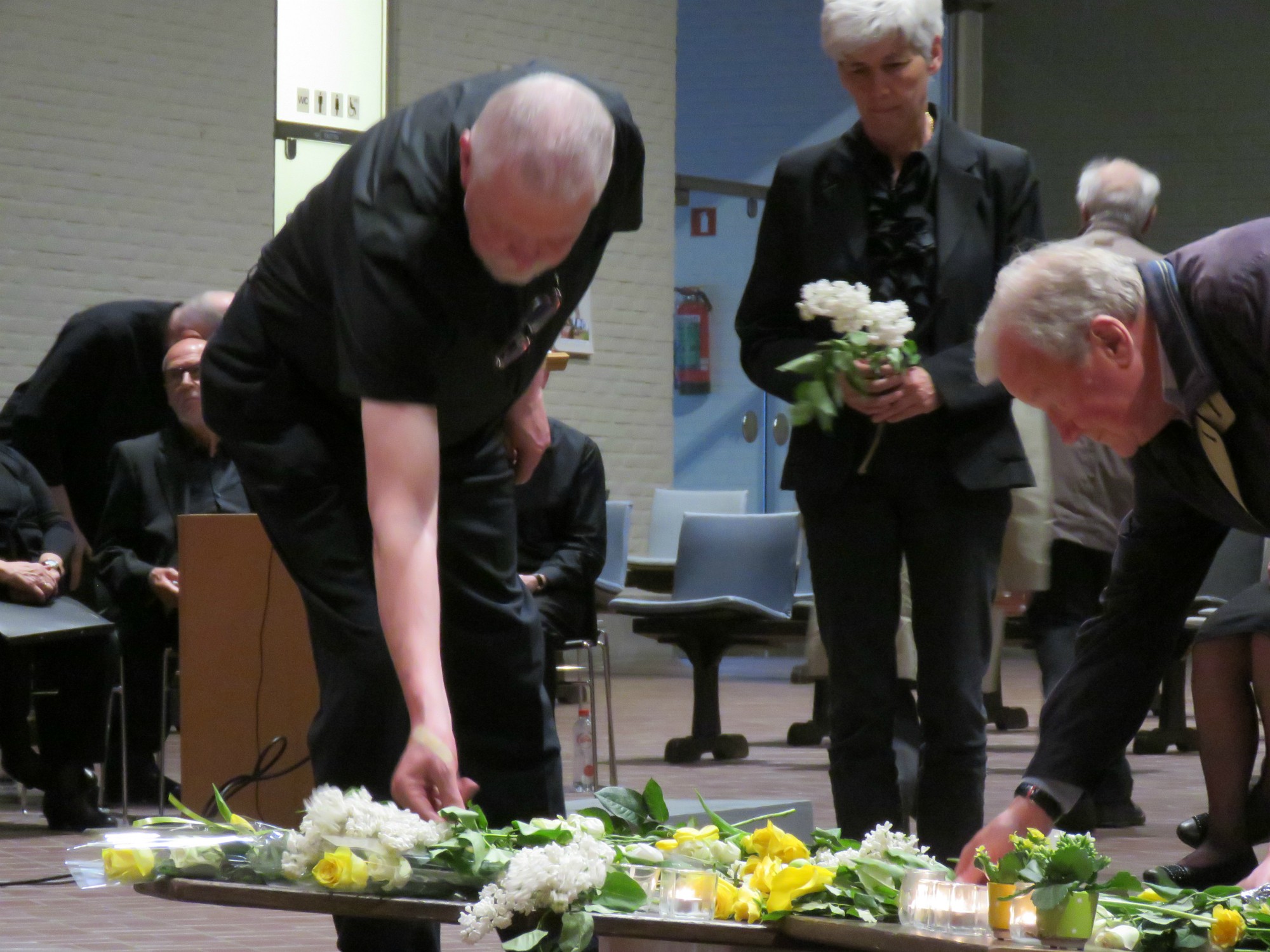 Goede Vrijdag - Kruishulde met bloemen en kaarsen