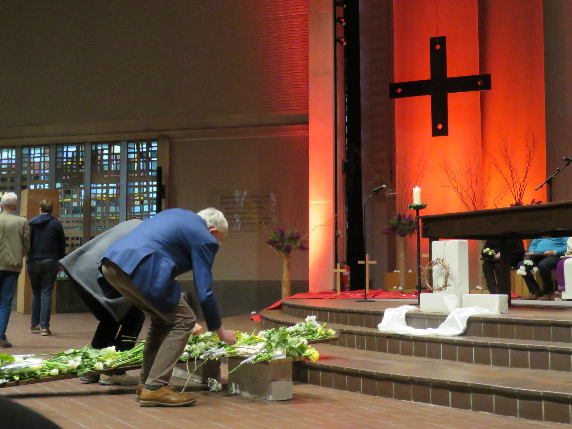 Goede Vrijdag - Kruishulde met bloemen en kaarsen