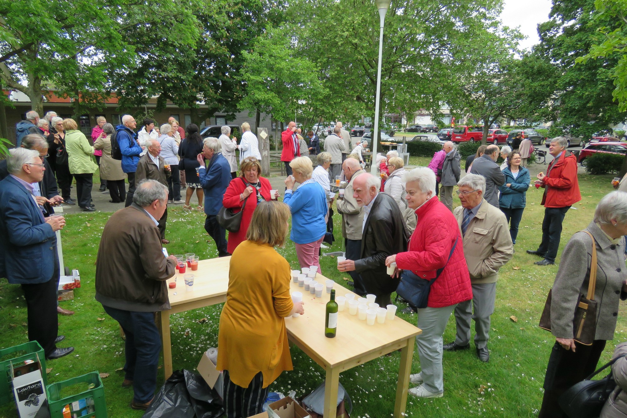 Receptie t.g.v. Rerum Novarum op het gras voor de kerk