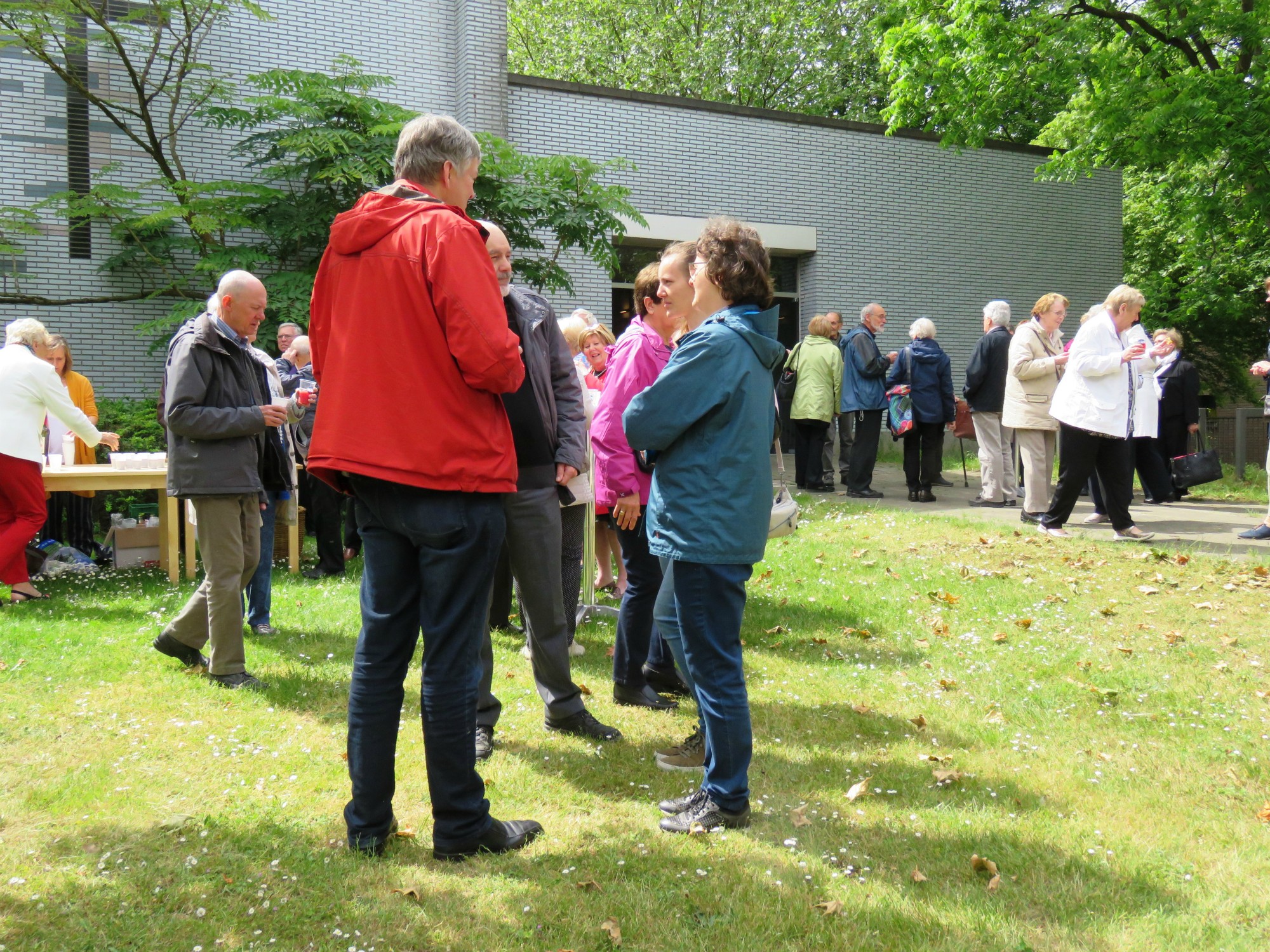 Receptie t.g.v. Rerum Novarum op het gras voor de kerk