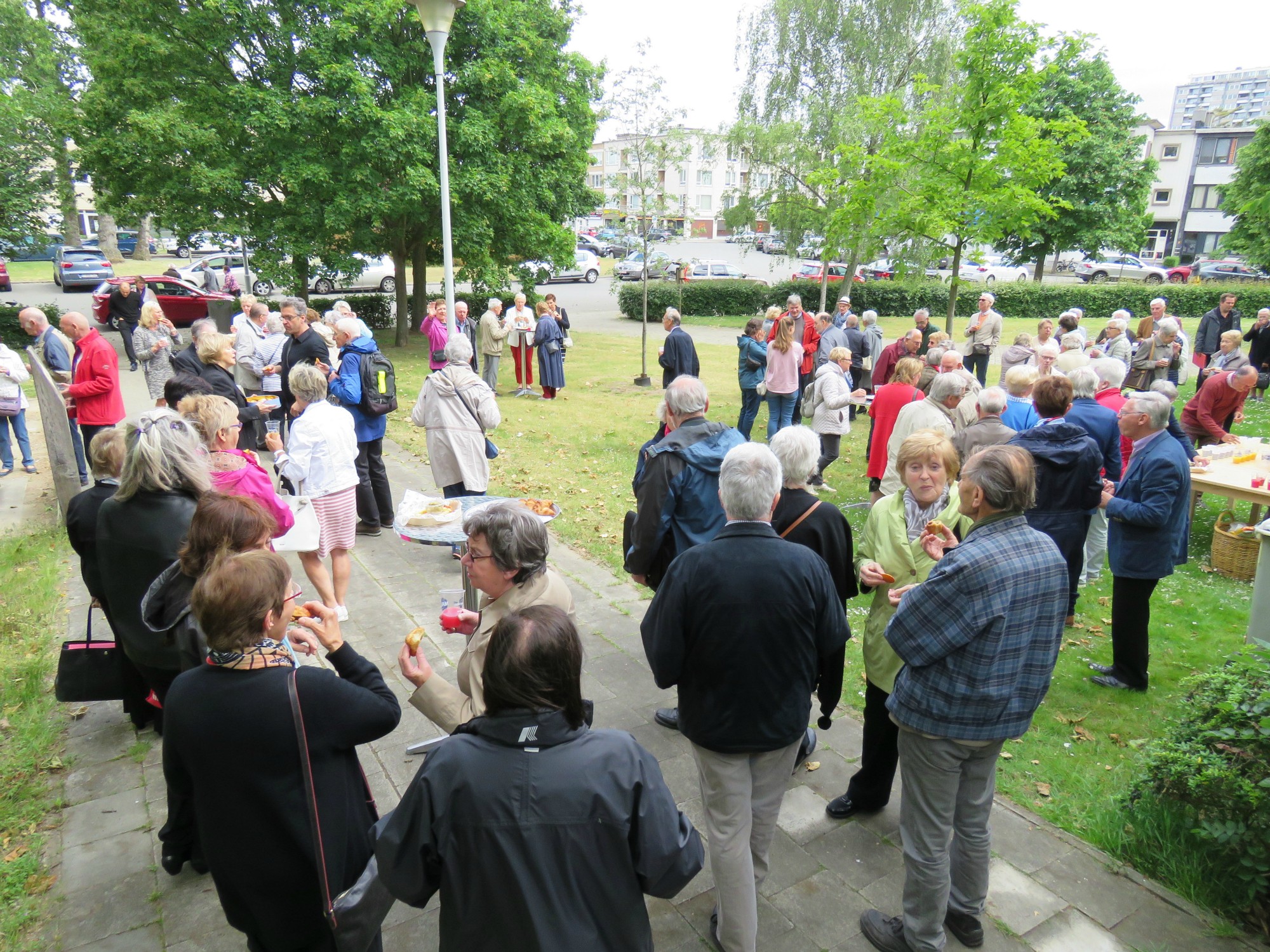 Receptie t.g.v. Rerum Novarum op het gras voor de kerk