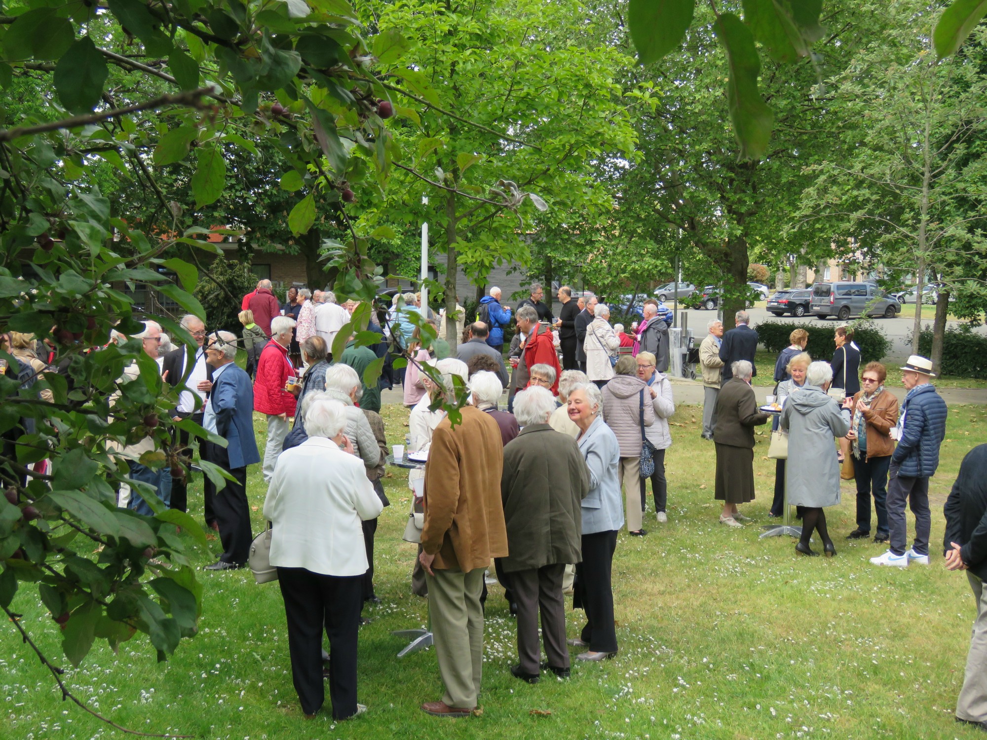 Receptie t.g.v. Rerum Novarum op het gras voor de kerk