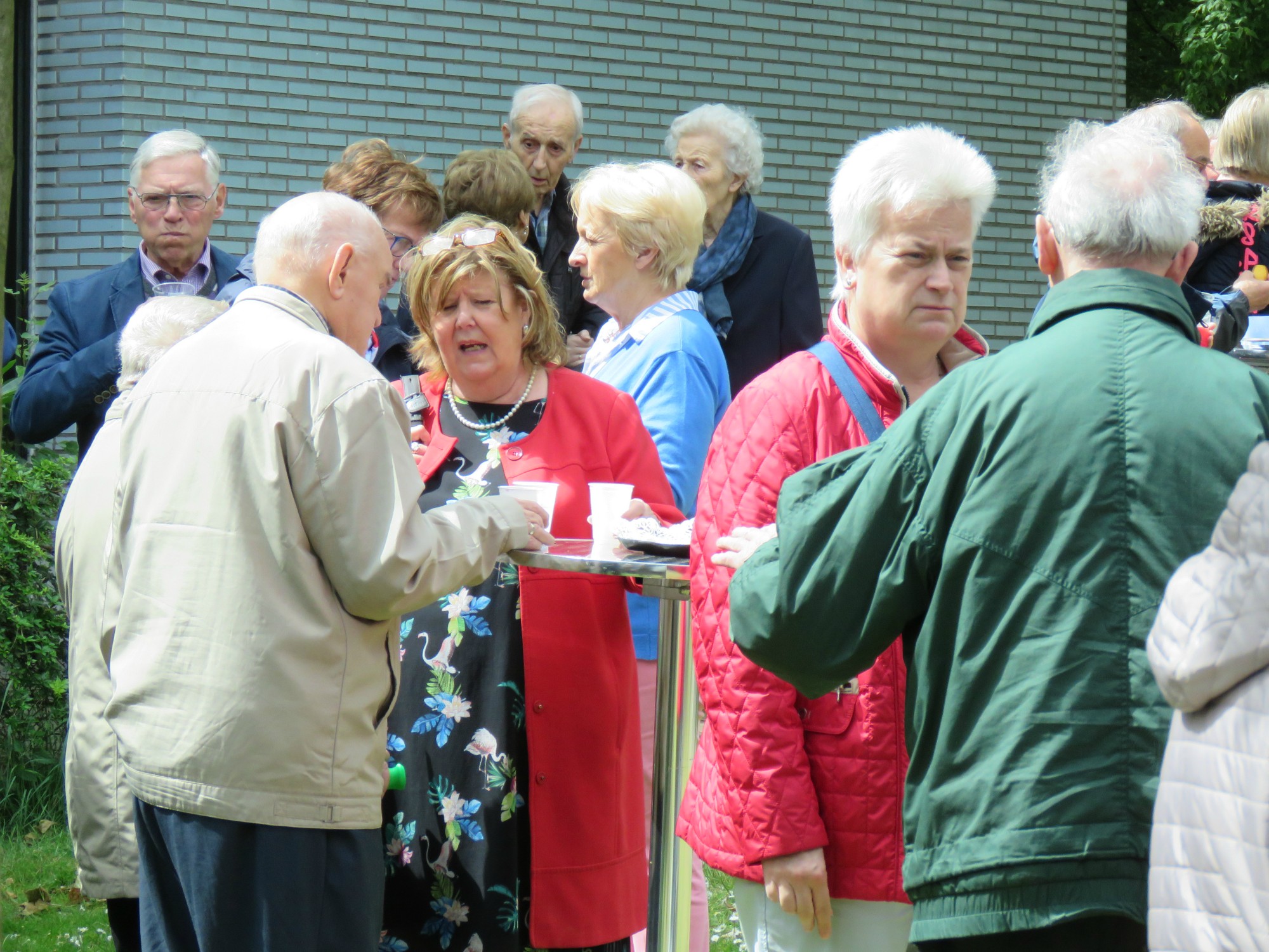 Receptie t.g.v. Rerum Novarum op het gras voor de kerk