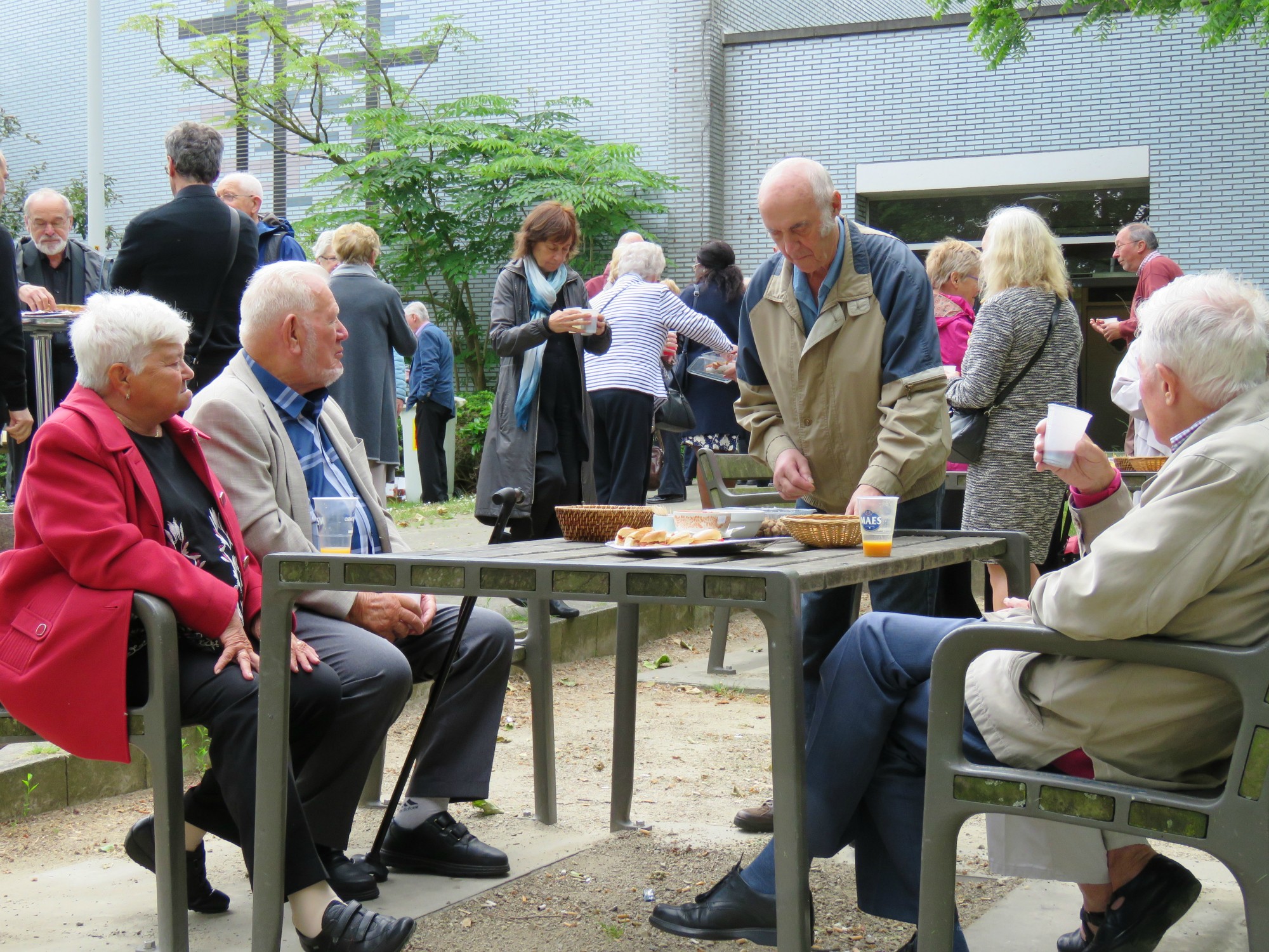 Receptie t.g.v. Rerum Novarum op het gras voor de kerk