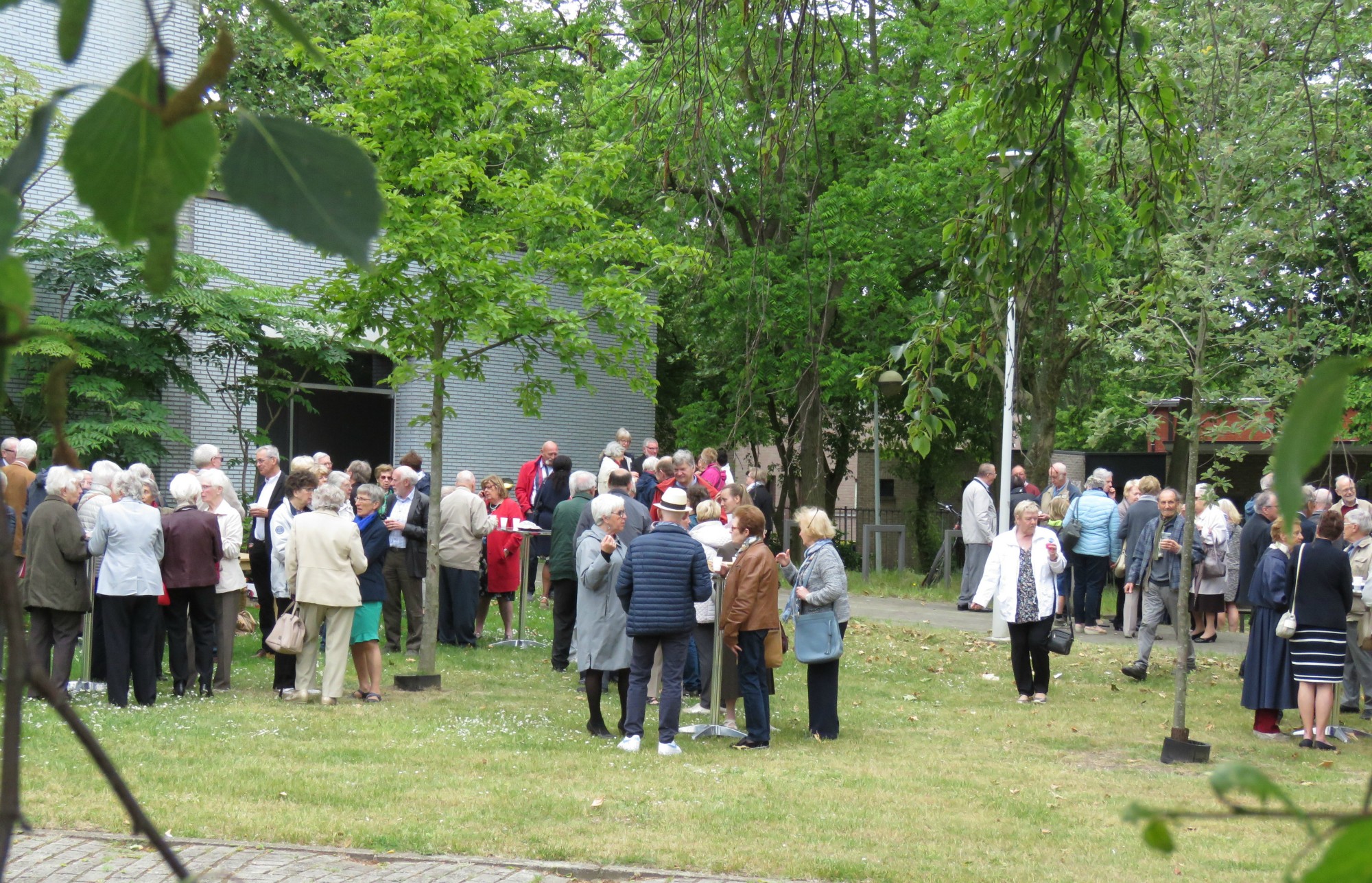 Receptie t.g.v. Rerum Novarum op het gras voor de kerk