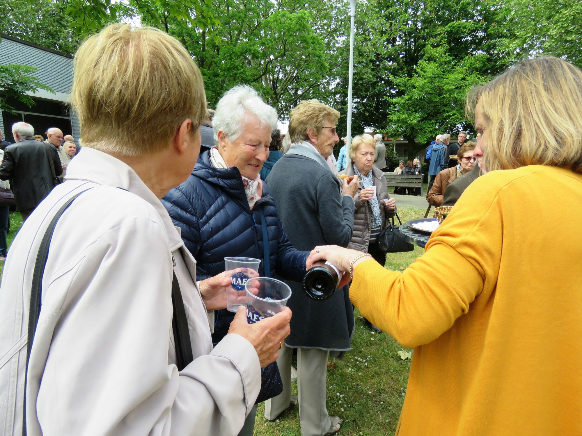 Receptie t.g.v. Rerum Novarum op het gras voor de kerk