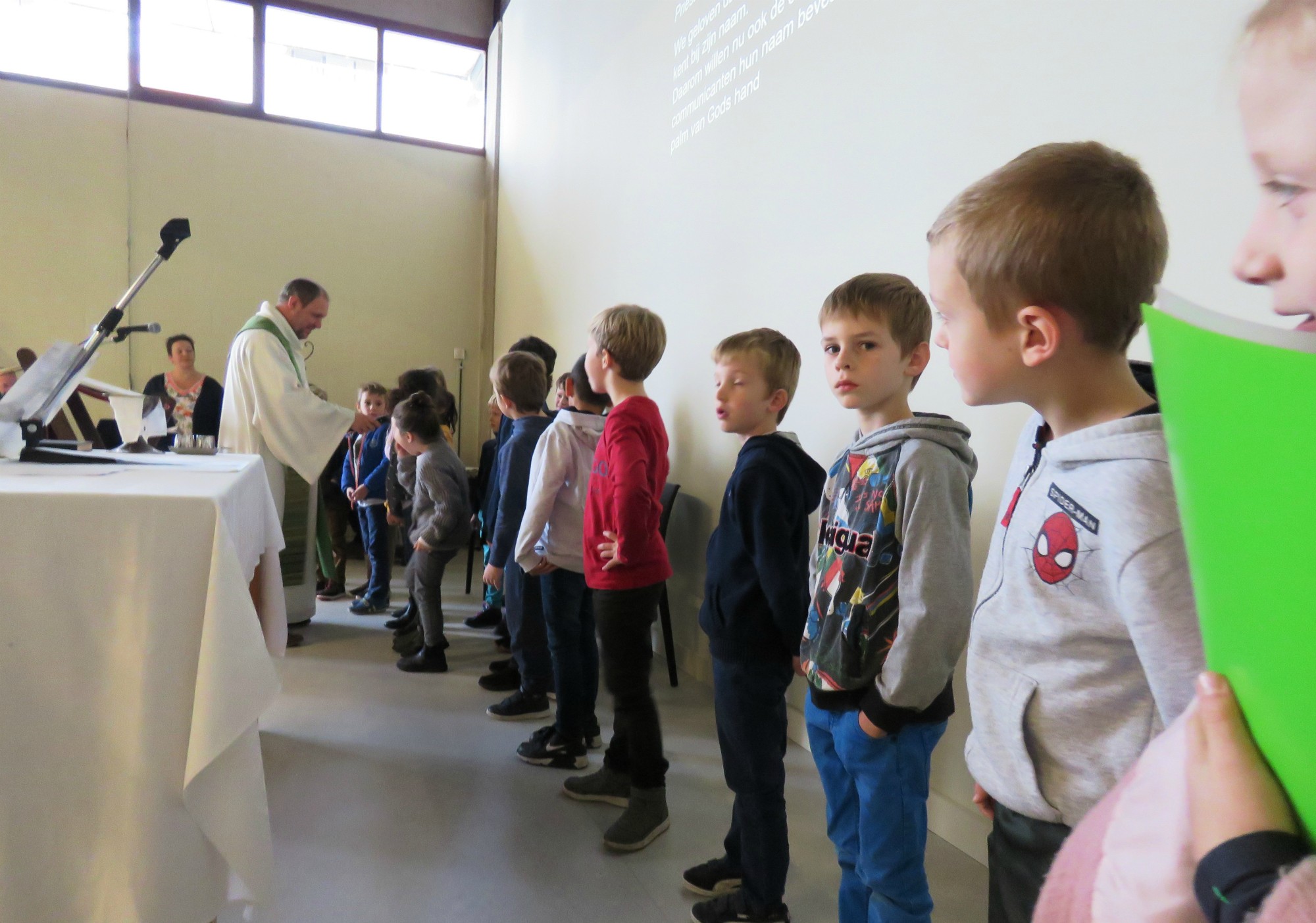 De eerste communicanten stellen zichzelf voor vooraan in de Sint-Lucaskerk