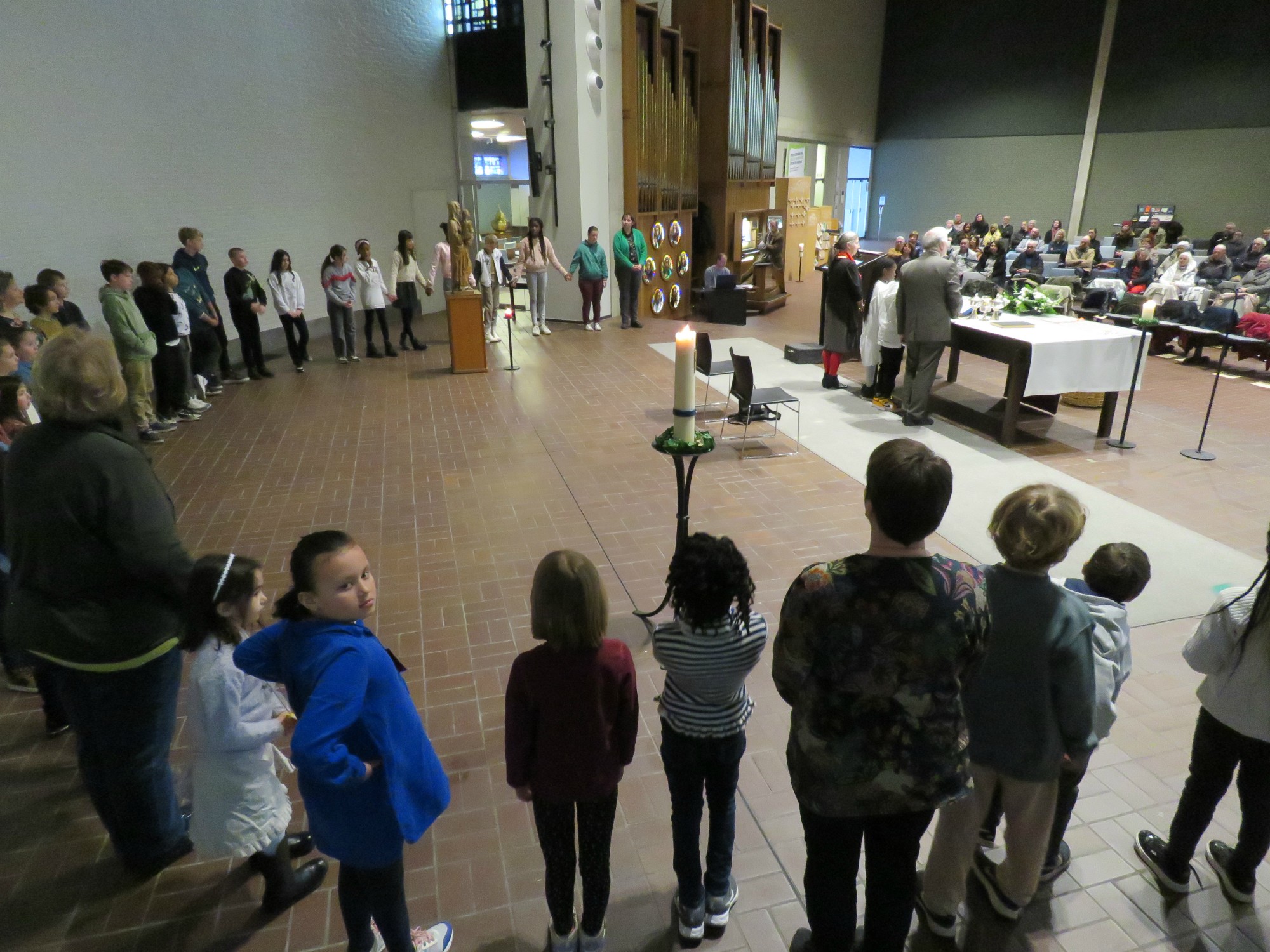 Alle kinderen in een grote kring rond het altaar