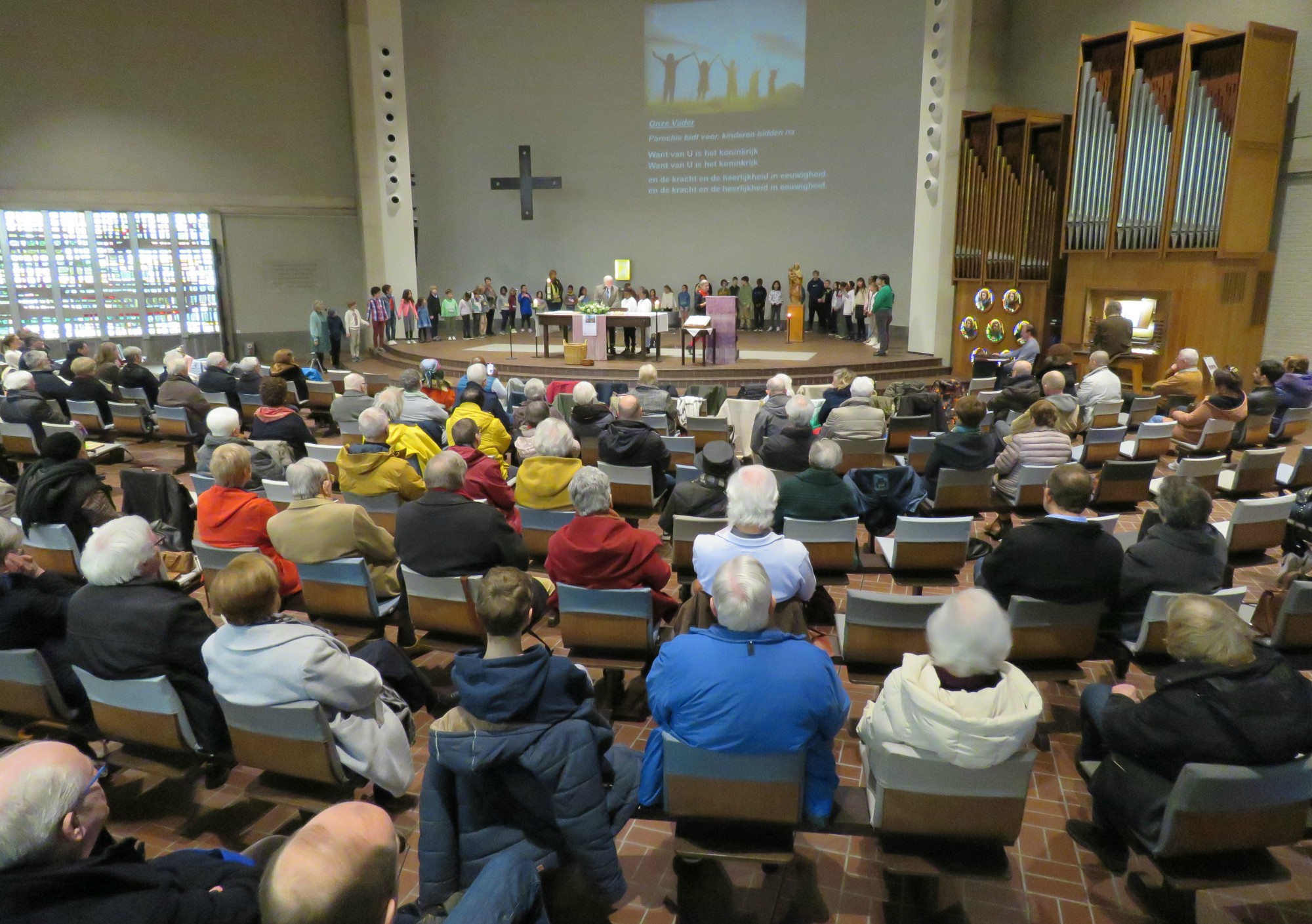 Alle kinderen in een grote kring rond het altaar