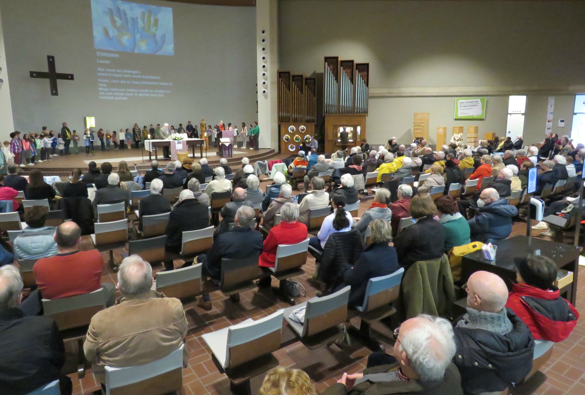 Alle kinderen in een grote kring rondom het altaar