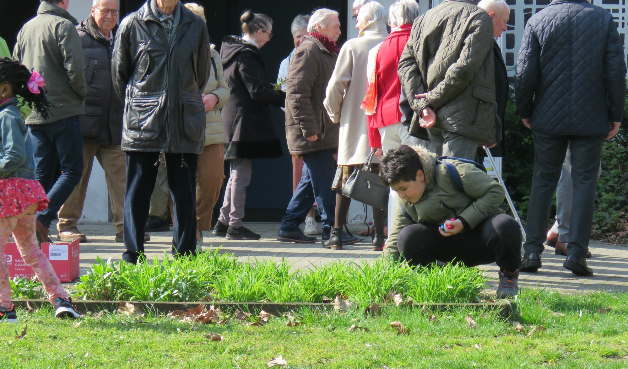 Pasen | Paaseieren rapen na de viering door de kinderen op het grasplein voor de kerk