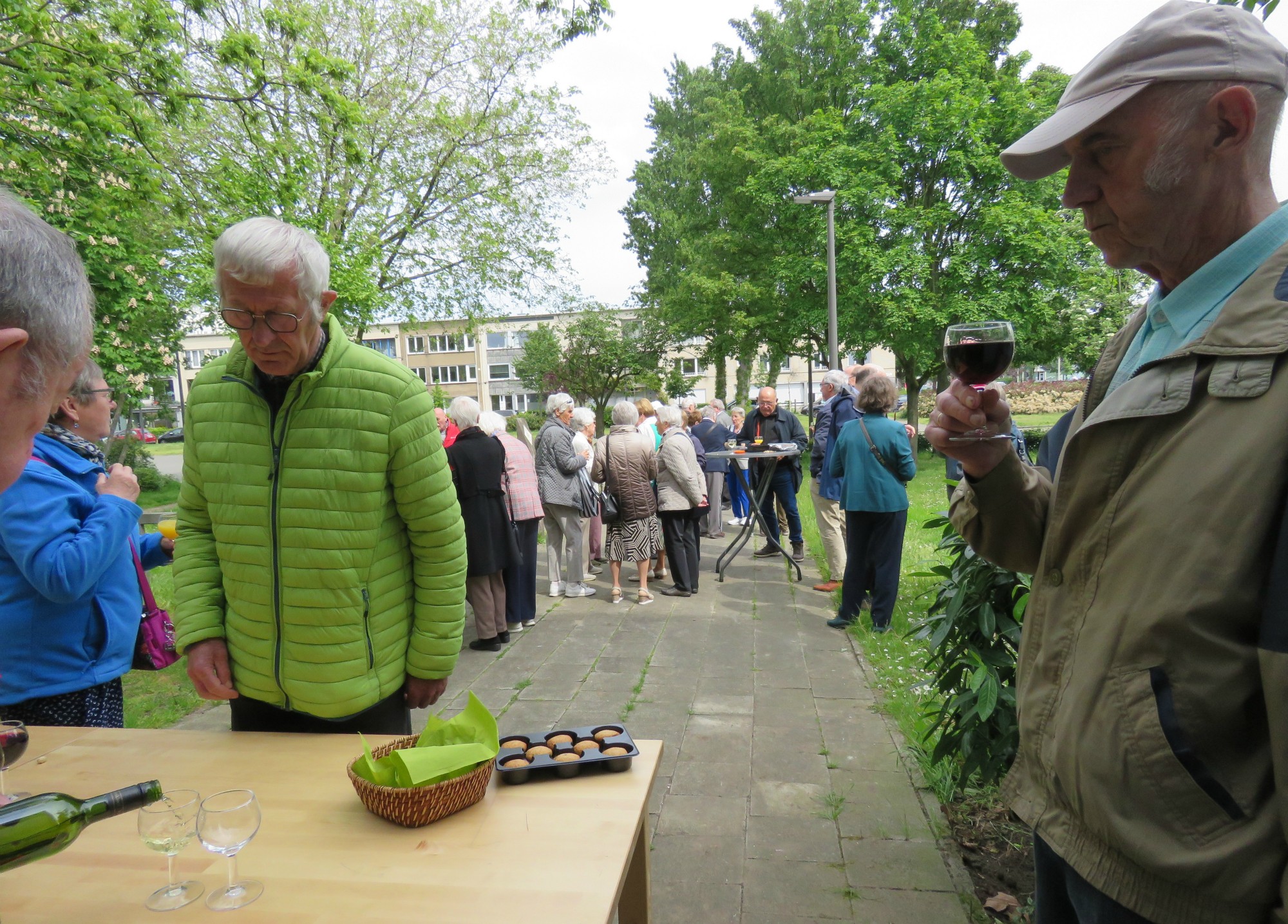 Receptie met deelmoment na de vieiring buiten in de zon aan de Sint-Anna-ten-Drieënkerk, Antwerpen Linkeroever