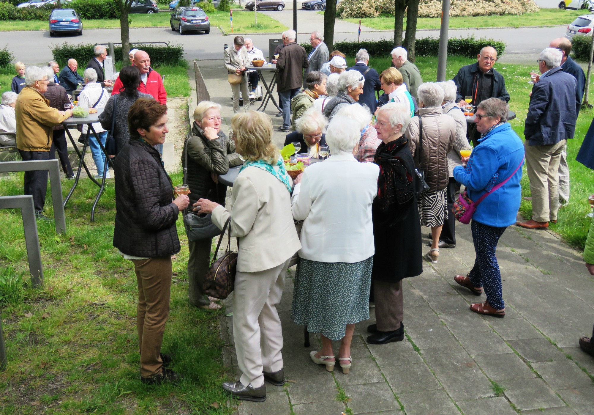 Receptie met deelmoment na de vieiring buiten in de zon aan de Sint-Anna-ten-Drieënkerk, Antwerpen Linkeroever