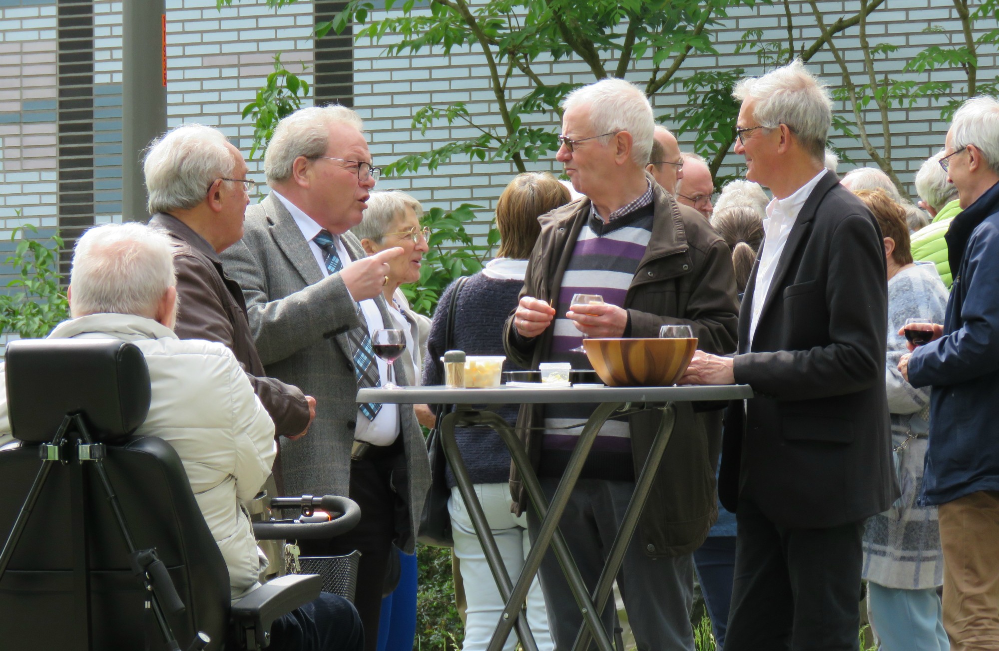 Receptie met deelmoment na de vieiring buiten in de zon aan de Sint-Anna-ten-Drieënkerk, Antwerpen Linkeroever