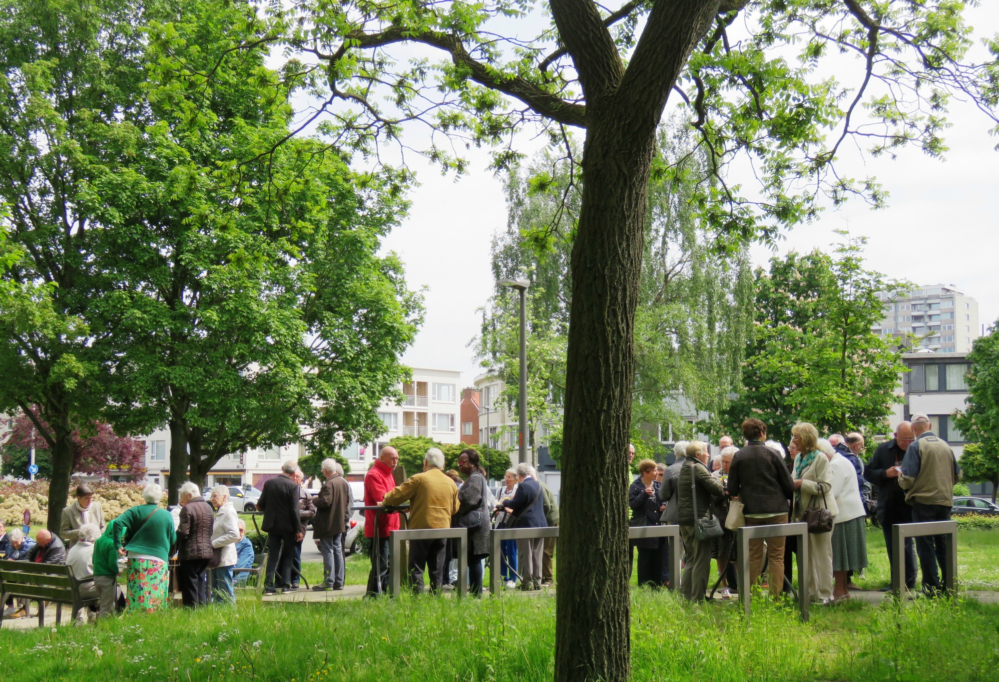 Receptie met deelmoment na de vieiring buiten in de zon aan de Sint-Anna-ten-Drieënkerk, Antwerpen Linkeroever