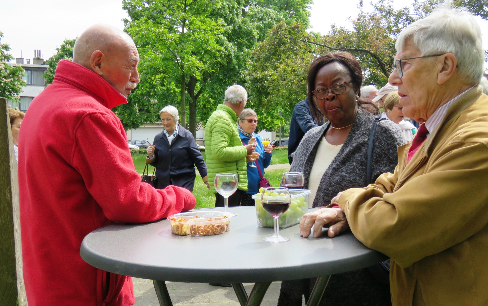 Receptie met deelmoment na de vieiring buiten in de zon aan de Sint-Anna-ten-Drieënkerk, Antwerpen Linkeroever