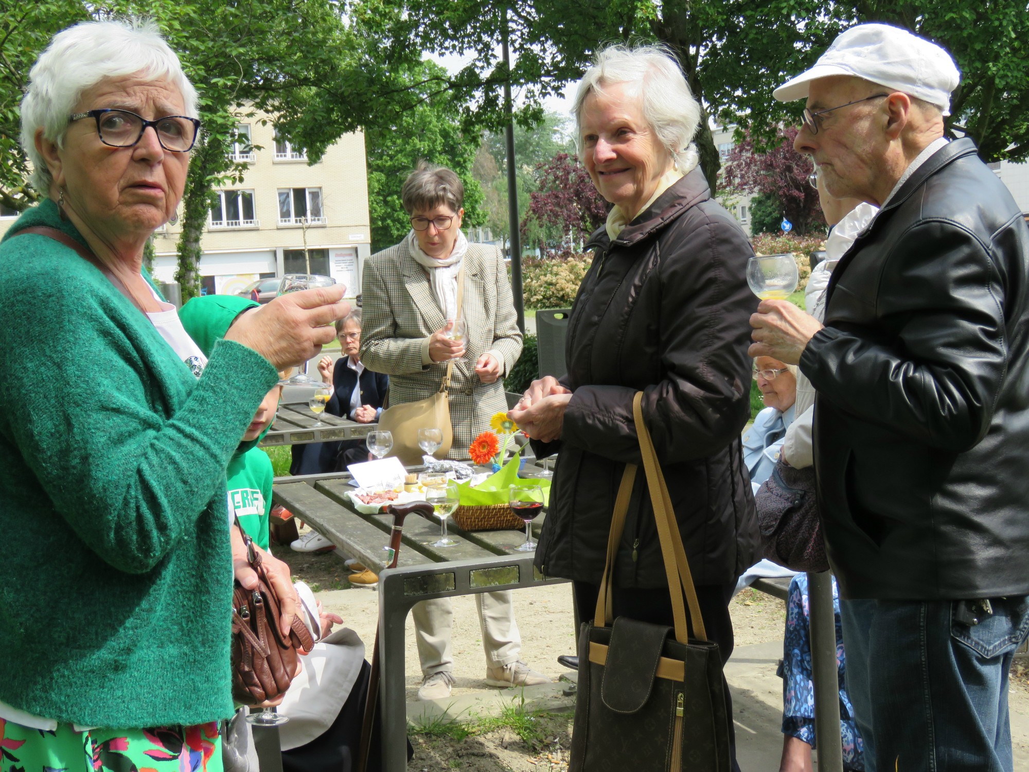 Receptie met deelmoment na de vieiring buiten in de zon aan de Sint-Anna-ten-Drieënkerk, Antwerpen Linkeroever