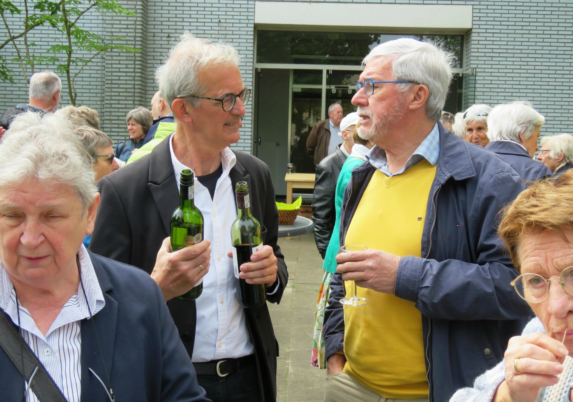 Receptie met deelmoment na de vieiring buiten in de zon aan de Sint-Anna-ten-Drieënkerk, Antwerpen Linkeroever