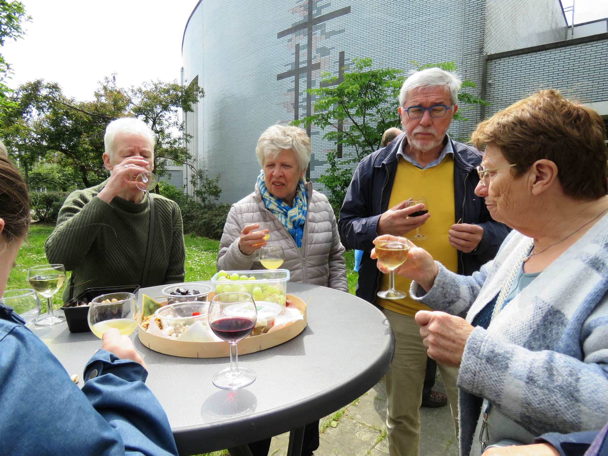 Receptie met deelmoment na de vieiring buiten in de zon aan de Sint-Anna-ten-Drieënkerk, Antwerpen Linkeroever