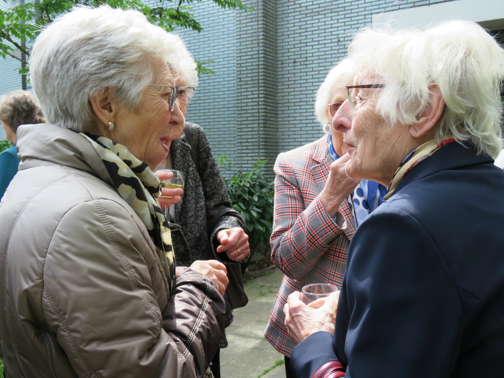 Receptie met deelmoment na de vieiring buiten in de zon aan de Sint-Anna-ten-Drieënkerk, Antwerpen Linkeroever