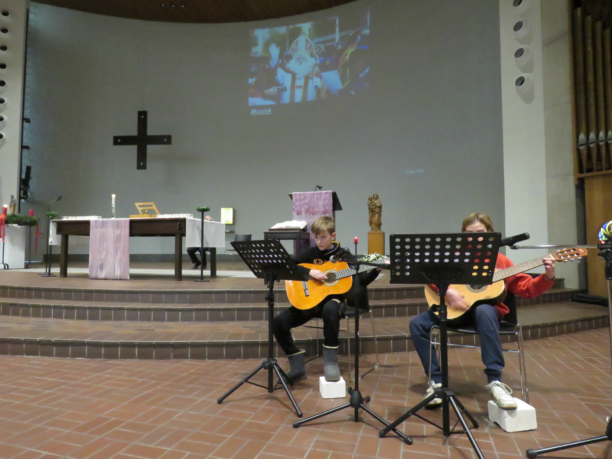 Twee vormelingen brengen samen met organist Joannes enkele Sinterklaasliedjes