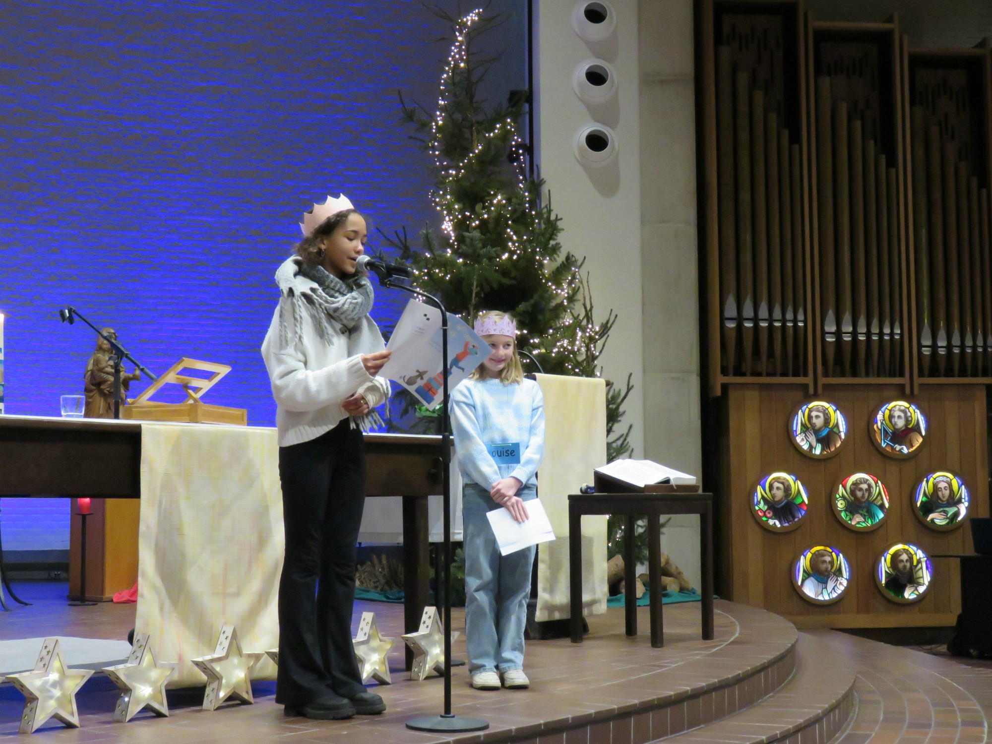 Een vormeling en eerste communicant lezen hun nieuwjaarsbrief voor