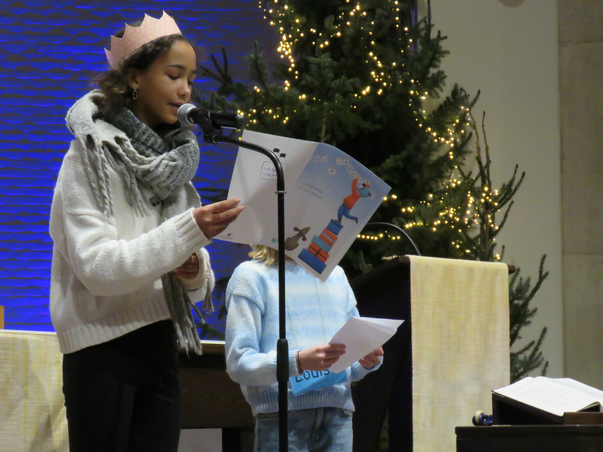 Een vormeling en eerste communicant lezen hun nieuwjaarsbrief voor