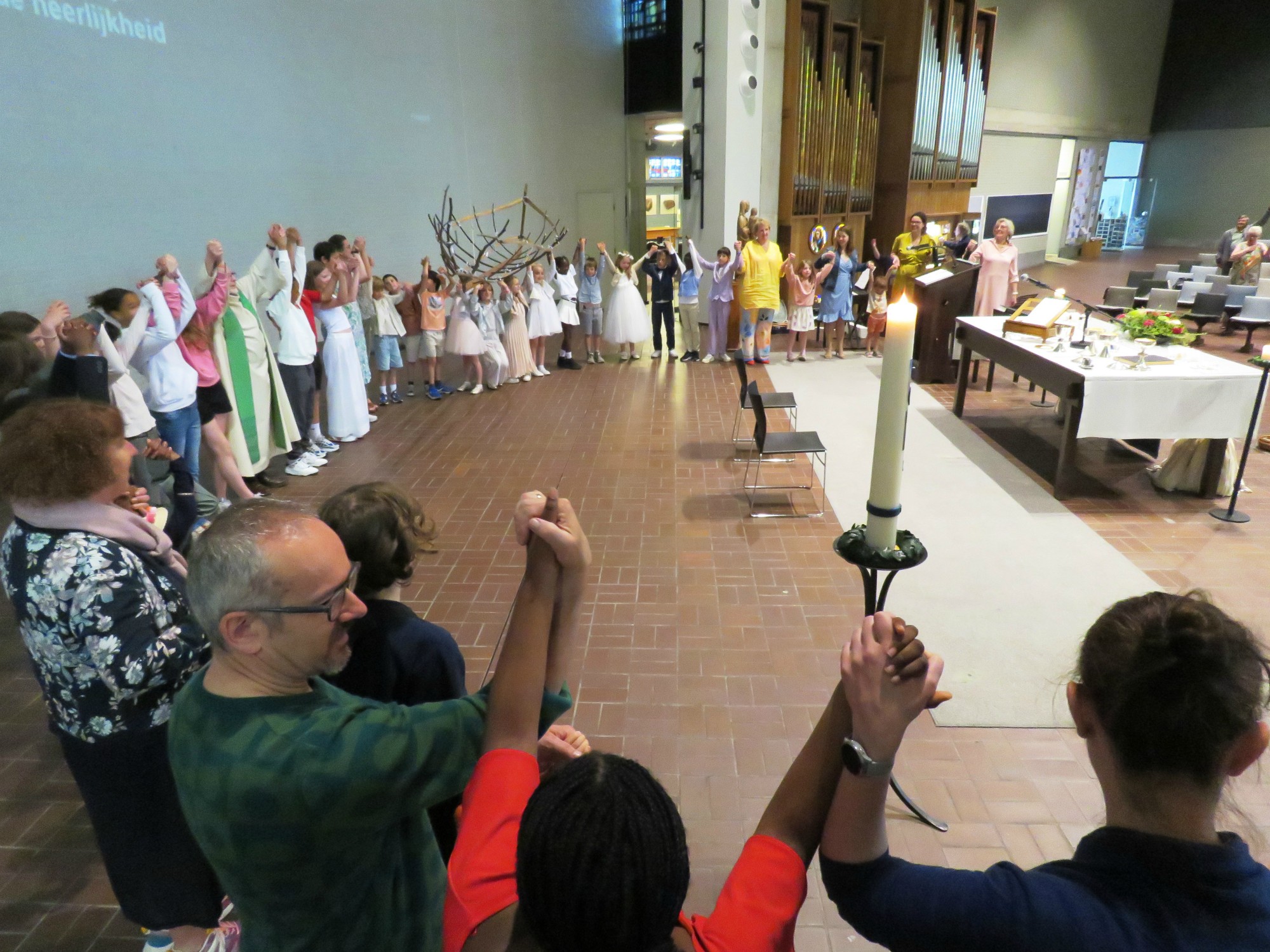 Alle kinderen rondom het altaar en iedereen hand in hand voor het Onze Vader