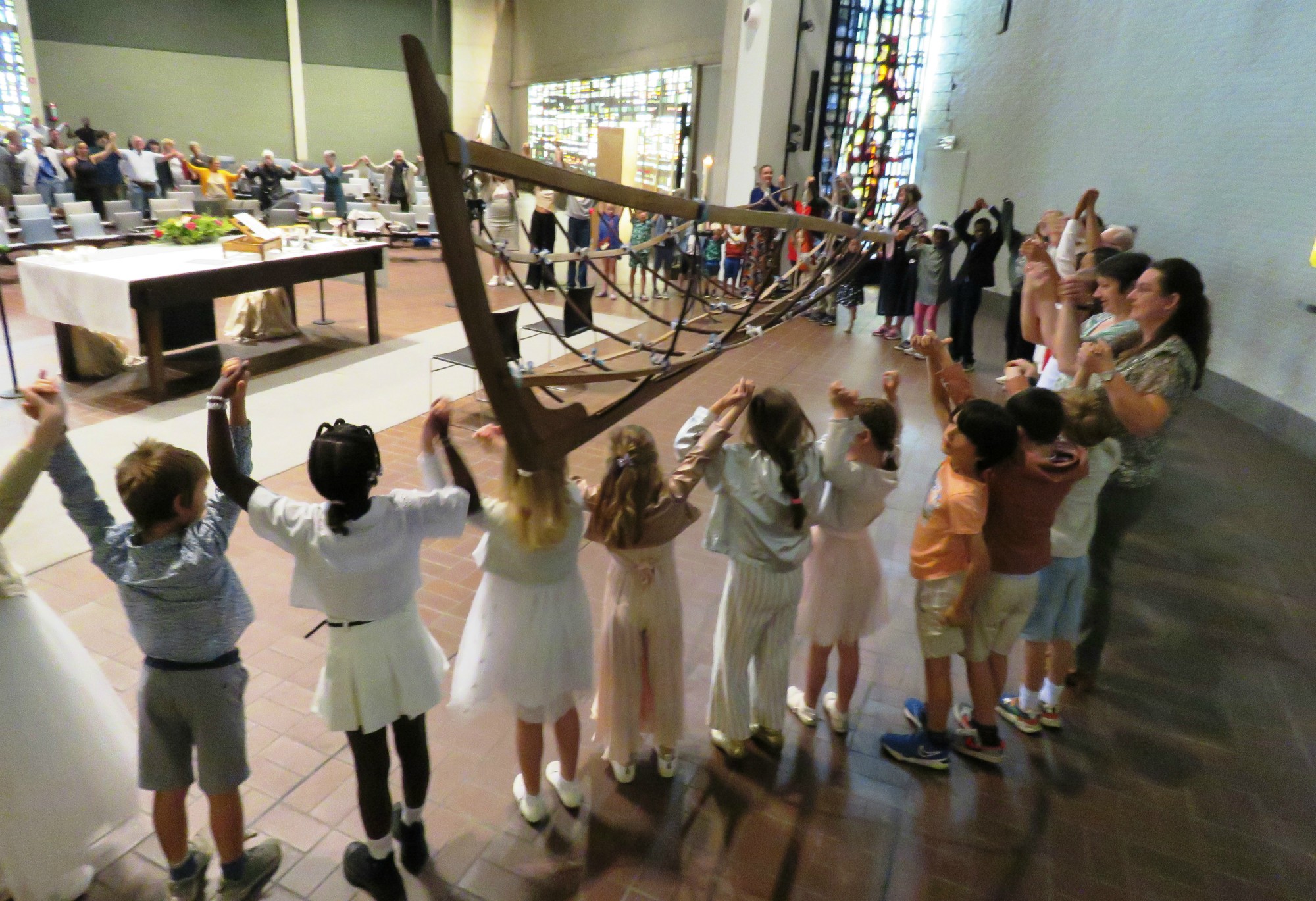 Alle kinderen rondom het altaar en iedereen hand in hand voor het Onze Vader