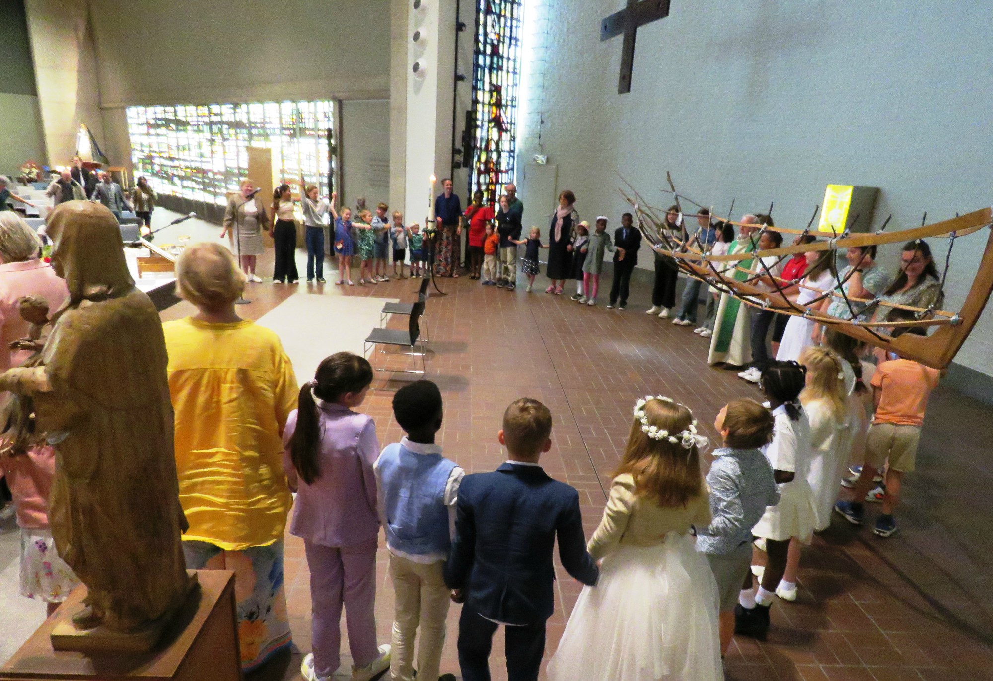 Alle kinderen rondom het altaar en iedereen hand in hand voor het Onze Vader