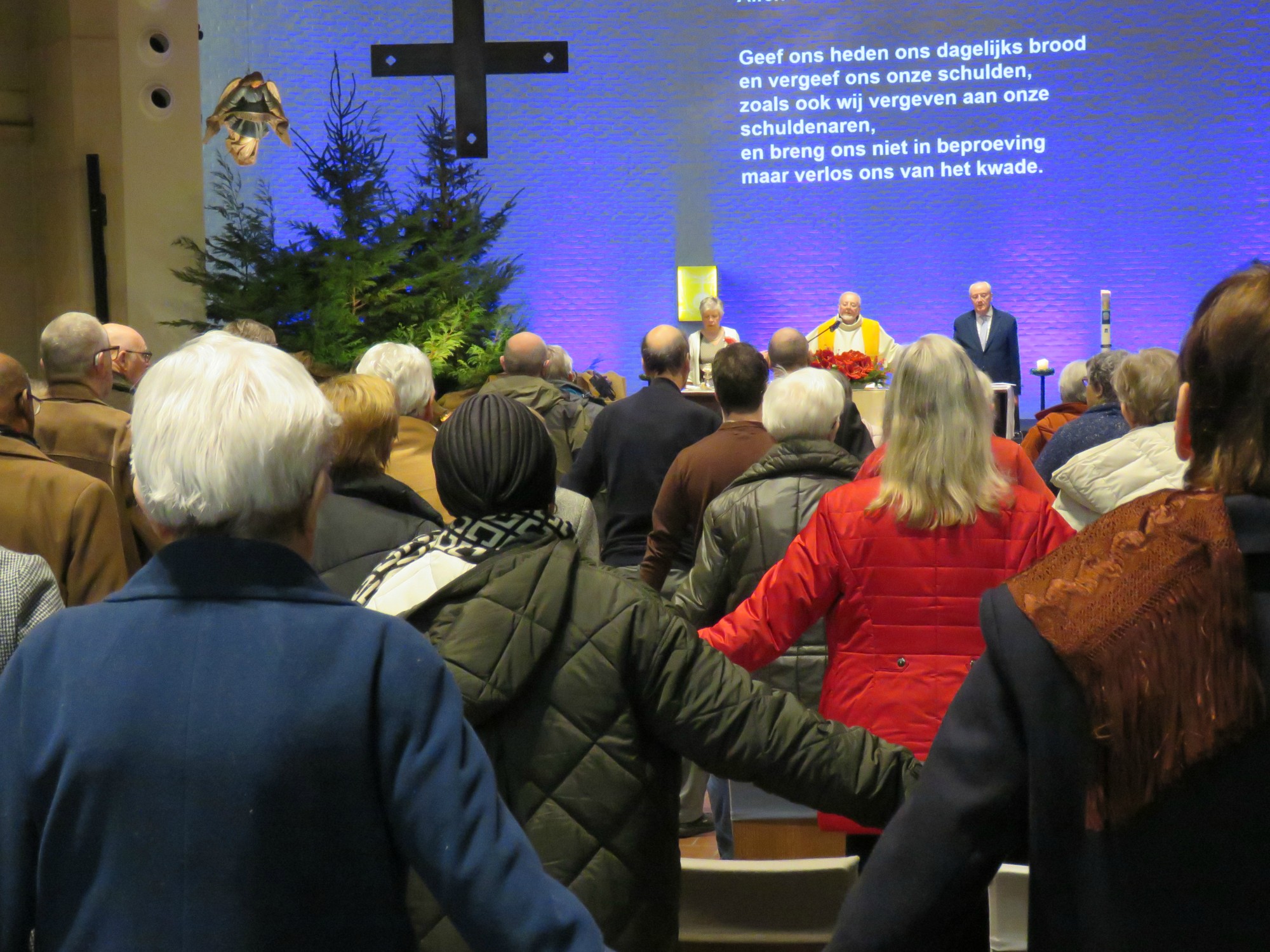 Kerstviering - Het Onze Vader, hand in hand, over de rijen heen