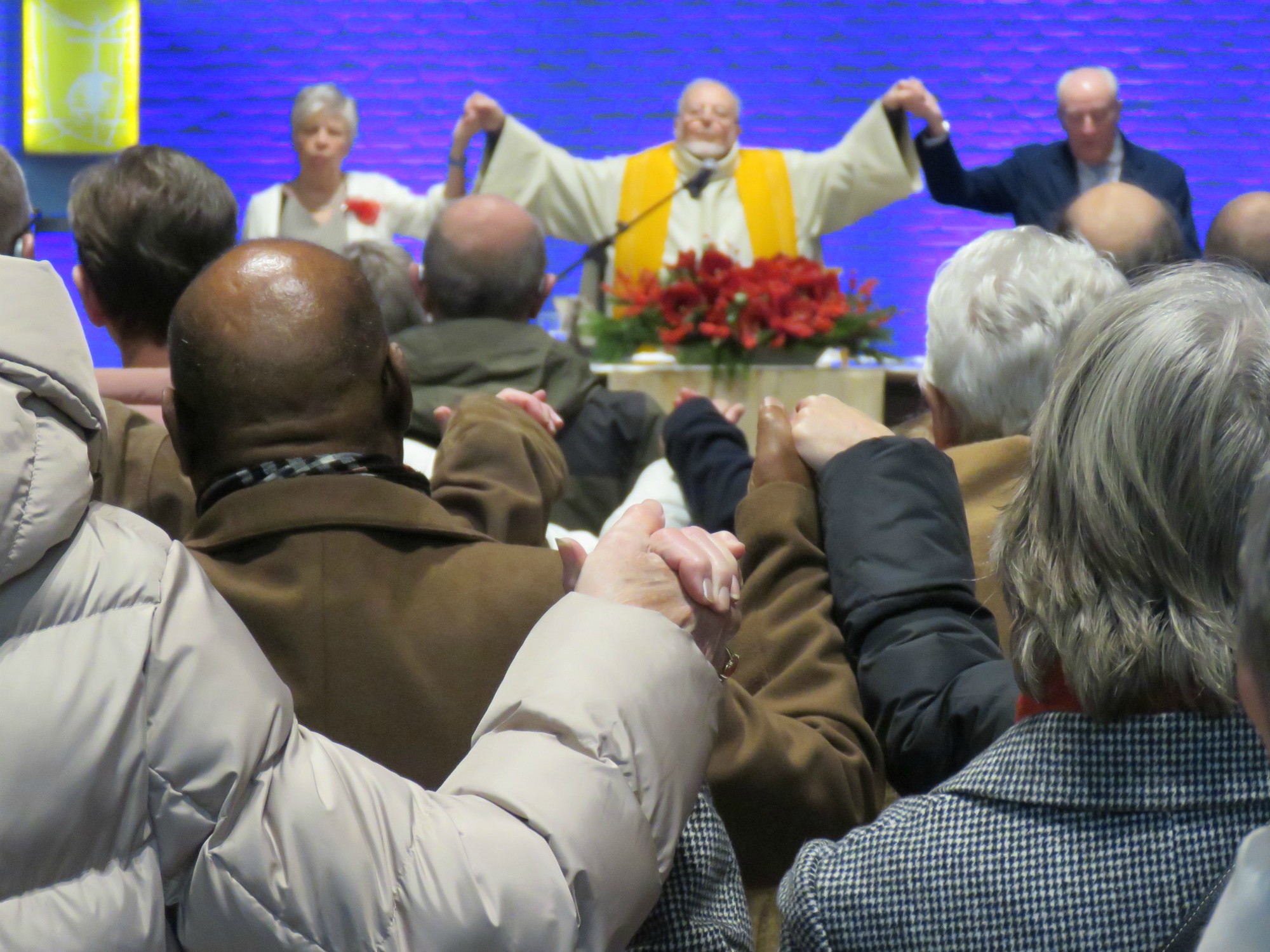 Kerstviering - Het Onze Vader, hand in hand, over de rijen heen